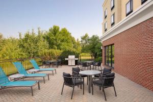 a patio with tables and chairs and a brick wall at TownePlace Suites Bangor in Bangor