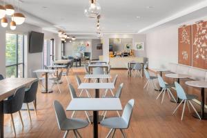 a restaurant with tables and chairs in a room at TownePlace Suites Bangor in Bangor