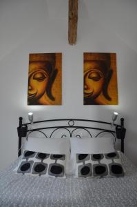 1 dormitorio con 1 cama con 2 cuadros en la pared en La Grange de la Gandonnerie en Baugé-en-Anjou