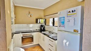 une cuisine avec un réfrigérateur blanc et un évier dans l'établissement Riverview Holiday Apartment 13 - Kalbarri, WA, à Kalbarri