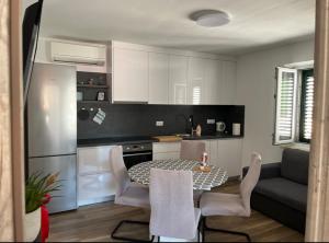 a kitchen with a table and chairs in a room at Apartmani Antonia in Račišće