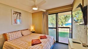 une chambre avec un lit et un balcon avec vue dans l'établissement Riverview Holiday Apartment 13 - Kalbarri, WA, à Kalbarri