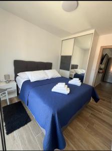 una camera da letto con un letto blu con sopra degli asciugamani di Apartmani Antonia a Račišće