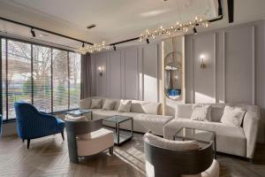 a living room with a white couch and chairs at Radisson Hotel Plovdiv in Plovdiv