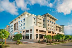 a white building with palm trees in front of a street at Courtyard by Marriott Redwood City in Redwood City