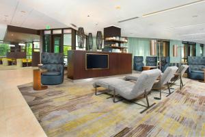 a lobby with chairs and a flat screen tv at Courtyard by Marriott Redwood City in Redwood City