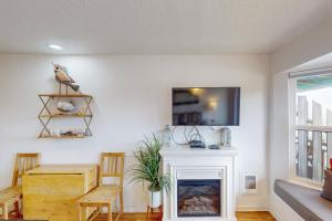 a living room with a fireplace and a tv at Neskowin Ocean Haven in Neskowin