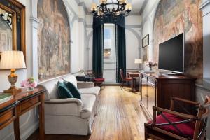 a living room with a couch and a tv at The St. Regis Florence in Florence +136 photos