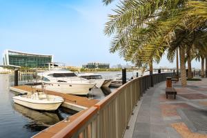 a group of boats docked at a marina with palm trees at Marriott Marquis Dubai Creek in Dubai