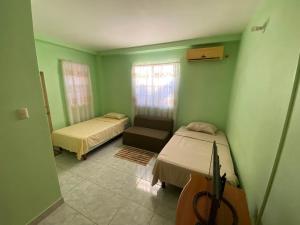 a green room with two beds and a couch at Runnyaway Inn in Bon Accord