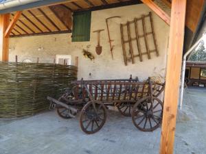 un viejo carro de madera aparcado en un granero en Bed & Breakfast Pergama en Haaren
