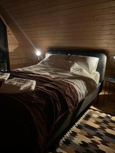 a bedroom with a large bed with a light on it at Hideaway Kazbegi in Kazbegi