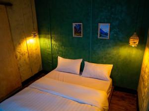 a bedroom with a bed with white sheets at Khaya Nzuri Romantic Hilltop Cabin with Virunga Views in Gasanze
