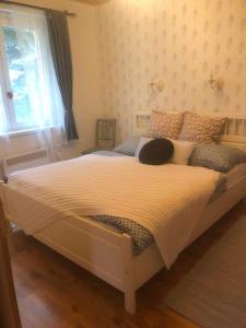 una camera da letto con un grande letto bianco con una finestra di Holiday home in Koröshegy - Balaton 51780 a Kőröshegy