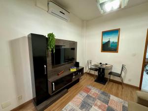 a living room with a flat screen tv and a table at Apartamento a 260m da Praia de Copacabana in Rio de Janeiro