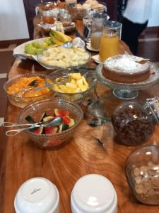 a wooden table topped with bowls of food and fruit at Lavanda Hotel Mira Serra in Celorico da Beira +24 photos
