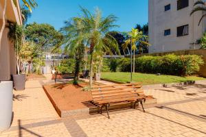 a group of benches in a park with palm trees at Flat Nobile Congonhas em frente ao aeroporto - H614 in São Paulo