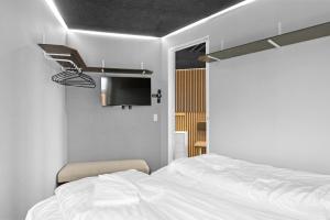 a bedroom with a white bed and a tv at Fun Art Holiday Apartment Lots Of Fun For The Whole Family! in Pandrup