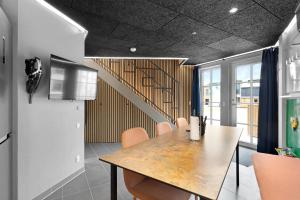 a dining room with a table and a staircase at Fun Art Holiday Apartment Lots Of Fun For The Whole Family! in Pandrup