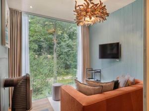 a living room with a couch and a large window at Stylish Stay with Sauna in Antoing