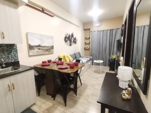 a kitchen and a living room with a table in a room at 2BR Charming Condo near Session road and Sm Goshenland Towers in Baguio