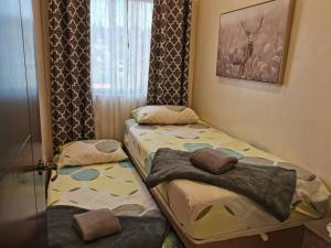 two twin beds in a room with a window at 2BR Charming Condo near Session road and Sm Goshenland Towers in Baguio