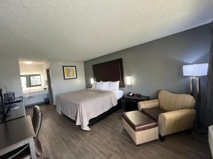 a hotel room with a bed and a chair at Quality Inn Kinder near Casino in Kinder +8 photos