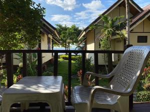 two white chairs and a table on a porch at Koh Chang Bailan Beach Resort in Ko Chang