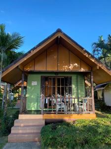 a green house with tables and chairs on the porch at Koh Chang Bailan Beach Resort in Ko Chang