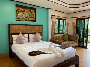 a bedroom with a large white bed and a couch at Koh Chang Bailan Beach Resort in Ko Chang