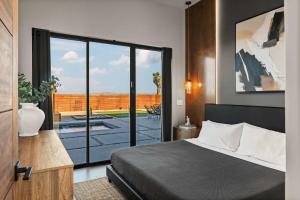 a bedroom with a bed and a view of a patio at Villas Pool-Spa- Fire pit- Golf in Joshua Tree +42 photos