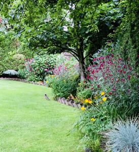 een tuin met kleurrijke bloemen en een boom bij Richmond Garden Retreat in Richmond