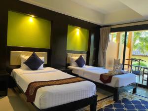two beds in a room with green and yellow walls at Koh Chang Bailan Beach Resort in Ko Chang