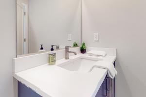 un bagno bianco con lavandino e specchio di Upstate NY Lake House a Lake George Altre 19 foto