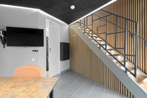a room with a staircase with a tv and a table at Rent A Holiday Apartment At Fun Art And Stay In A Mecca Of Art And Experiences!  in Pandrup +14 photos