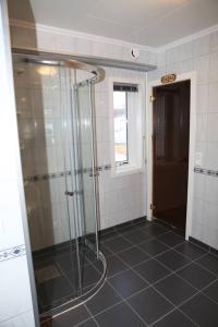 a bathroom with a shower with a glass door at Utsikten Feriehus i Bakkeby in Bakkeby