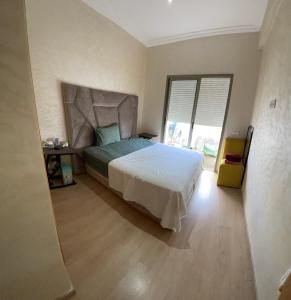 Appartement avec piscine à casa tamaris في دار بوعزة: غرفة نوم بها سرير ونافذة كبيرة