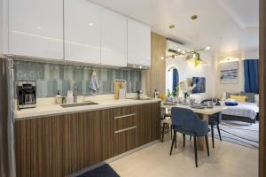 a kitchen and living room with a table and a kitchen and a dining room at Cerulean Bliss Condo at Tambuli Mactan Fast Wifi Netflix in Lapu Lapu City