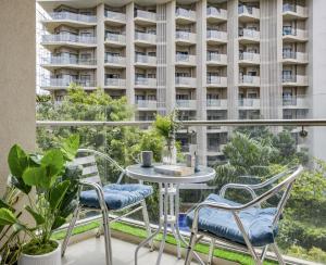 a balcony with a table and chairs and a building at Cerulean Bliss Condo at Tambuli Mactan Fast Wifi Netflix in Lapu Lapu City