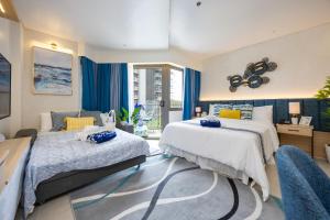 a bedroom with two beds and a couch at Cerulean Bliss Condo at Tambuli Mactan Fast Wifi Netflix in Lapu Lapu City +46 photos