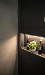 a bathroom with two bottles on a shelf with flowers at Aerosuites in Bogotá
