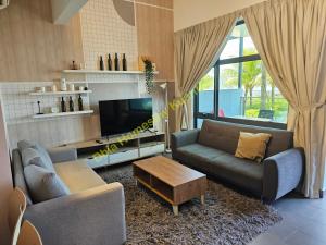 a living room with two couches and a tv at Dhia Homestay Kuantan in Kampung Peramu