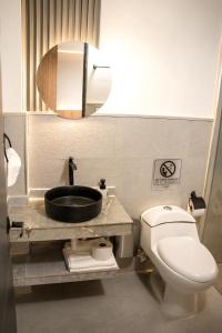 a bathroom with a sink and a toilet and a mirror at Aerosuites in Bogotá +23 photos