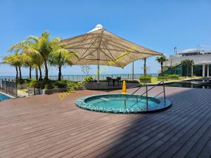 a large umbrella on top of a wooden deck at Dhia Homestay Kuantan in Kampung Peramu