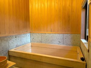 京都市にある京町家の宿  あんどの木製の壁の客室で、バスタブが備わります。 +11枚の写真