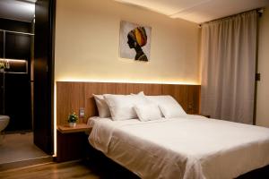 a bedroom with a large bed with white sheets at Aerosuites in Bogotá