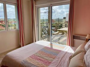a bedroom with a bed and a view of a balcony at Duplex élégant 3 chambres avec terrasses, draps fournis, WiFi, jardin, à Ambleteuse - FR-1-376-9 in Ambleteuse