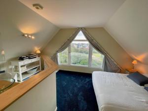 a attic bedroom with a bed and a window at Triplex de standing à Ambleteuse avec terrasse, parking et Wifi - FR-1-376-26 in Ambleteuse