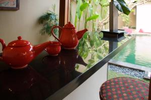 a table with two red vases sitting on top of it at Ajanta Villa in Sanur