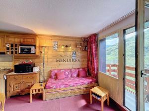 ein Wohnzimmer mit einem rosa Sofa in einem Zimmer in der Unterkunft 2 pièces cabines idéal pour 5 pers, proche pistes, parking, Wi-Fi, animaux admis - FR-1-178-394 in Les Bruyères